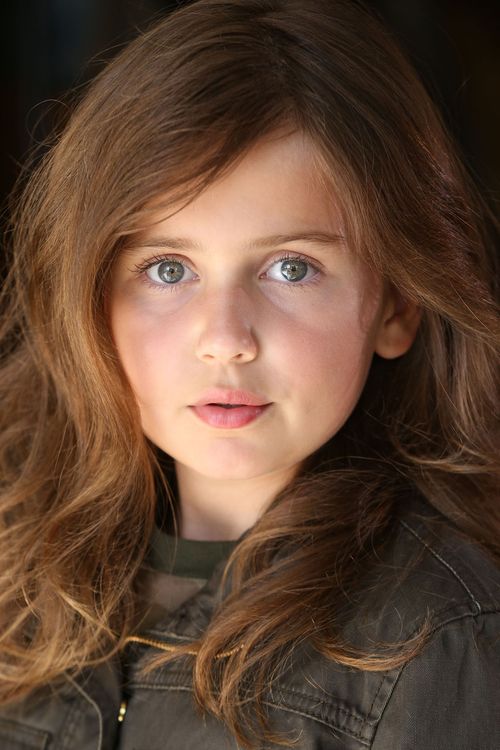 Close-up portrait of actress Caroline Brauner with loose brown hair and green eyes wearing a dark jacket. Photo by Deidhra Fahey.