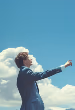 Three masked cleaning staff mopping the floor in a living room with a gray sofa and plant.