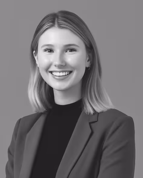 Dirt road winding through a golden wheat field with wind turbines in the background under a blue sky.