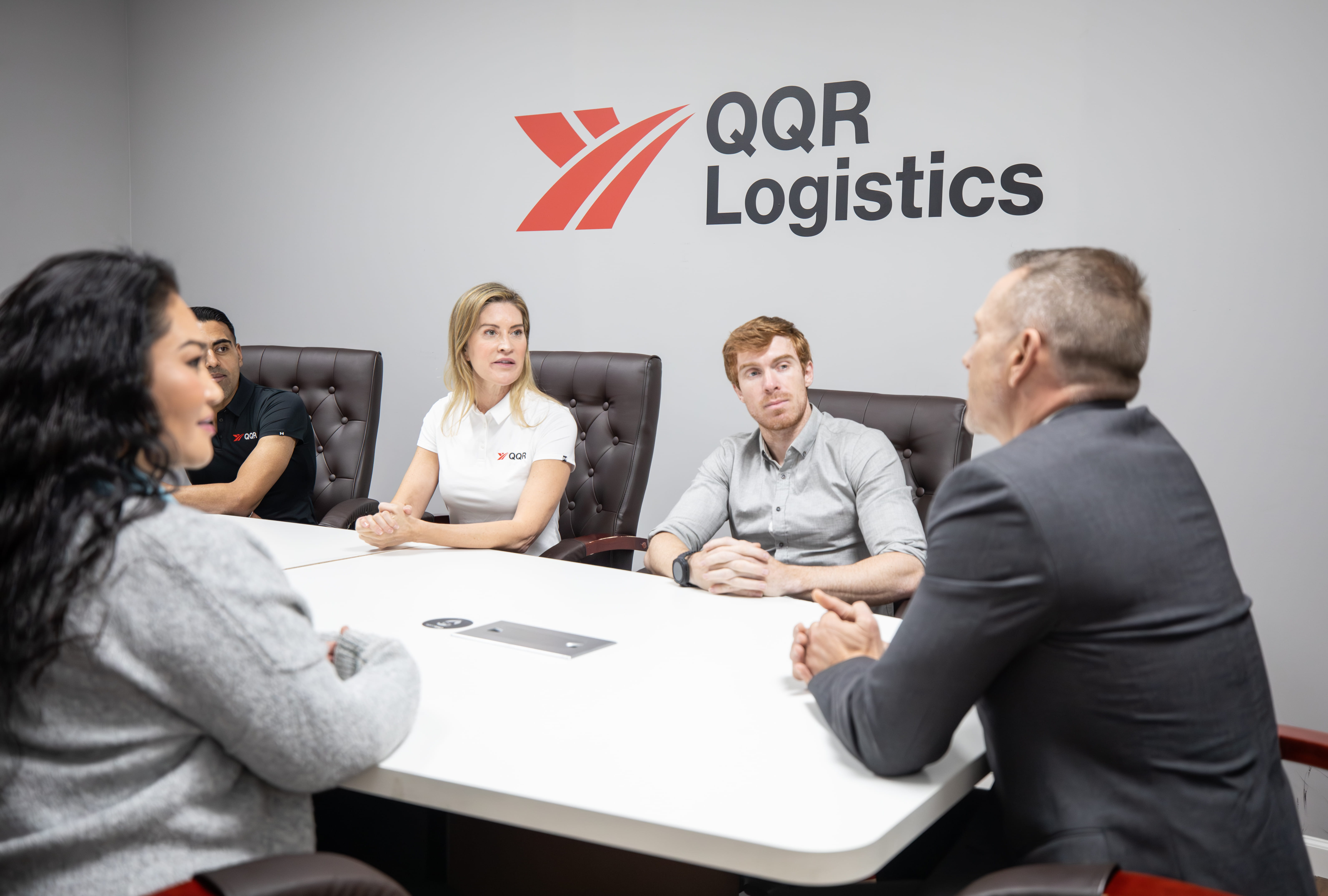 QQR Logistics team members having a business meeting around conference table