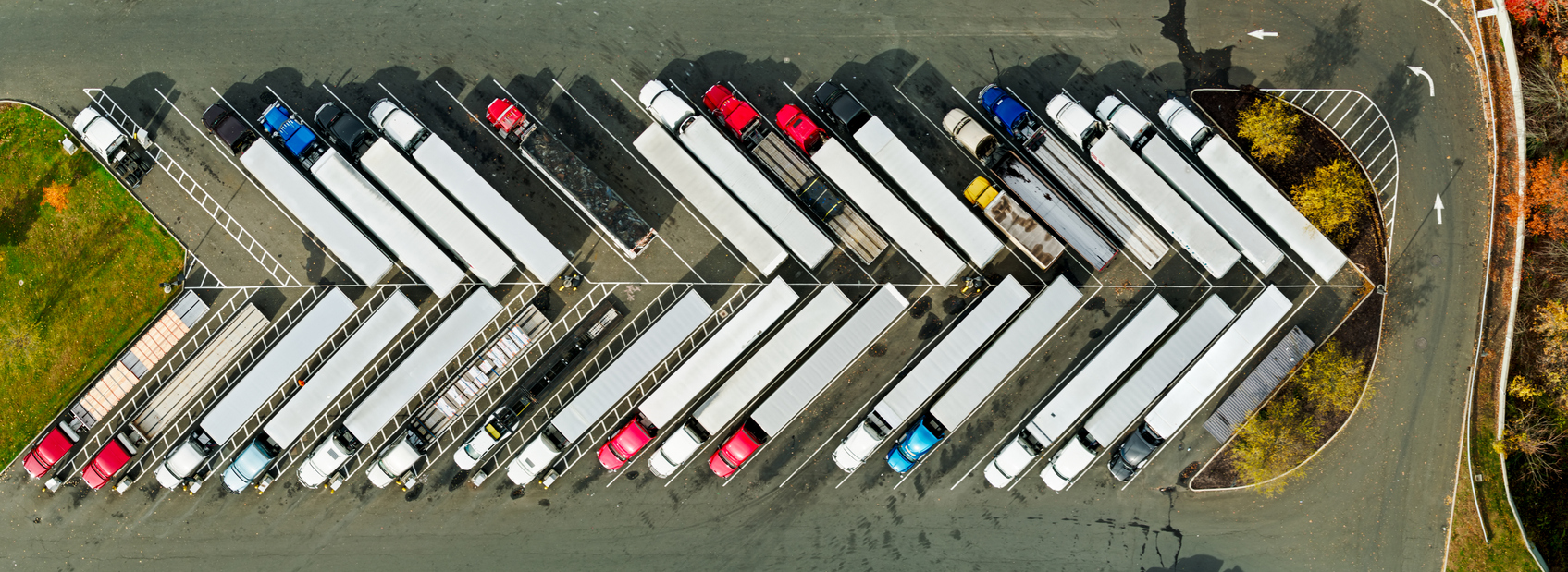 Aerial view of a busy truck stop with rows of parked semi-trucks