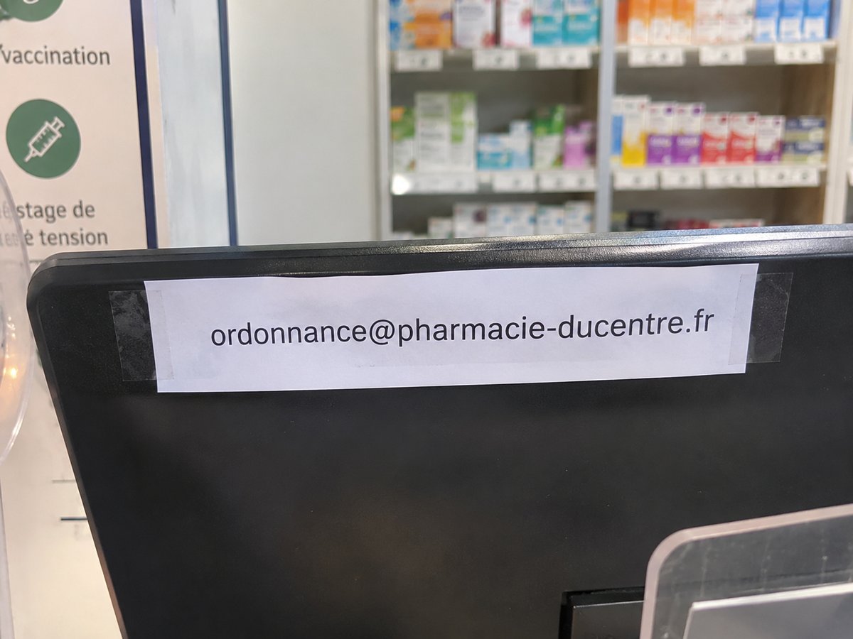 Adresse e-mail pour les ordonnances scotchée sur l’écran d’un comptoir de pharmacie
