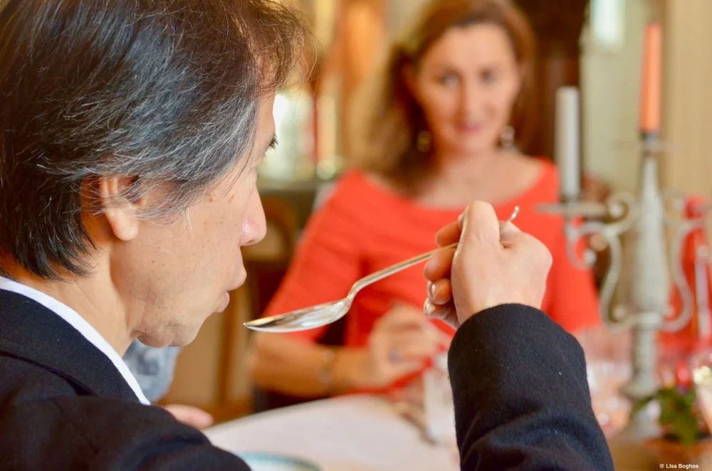Un homme apprenant à déguster une soupe avec élégance sous les conseils de France de Heere, lors d'un atelier pratique sur les bonnes manières à table.