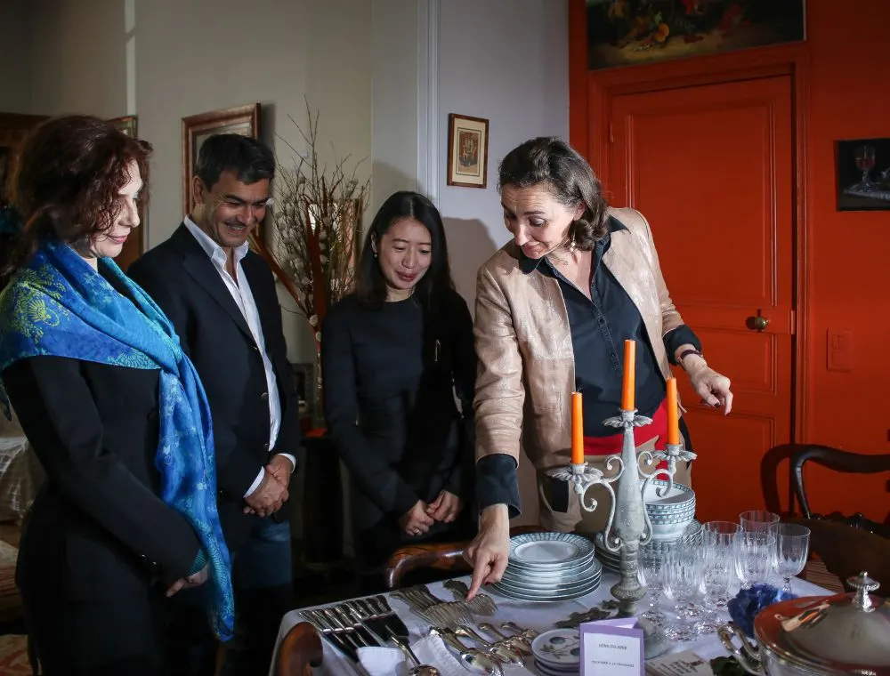 France de Heere expliquant la disposition des couverts et les règles du dressage d'une table élégante lors d'un atelier collectif de savoir-vivre.