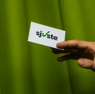 Hand houdt Sjuste kaartje vast tijdens behind the scenes marketing en videoproductie