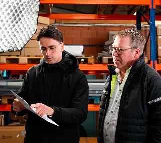 Marketingteam bespreekt videoconcept tijdens opname op locatie in magazijn