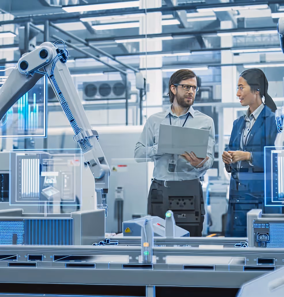 Deux ingénieurs discutant devant une machine automatisée dans un laboratoire de haute technologie.