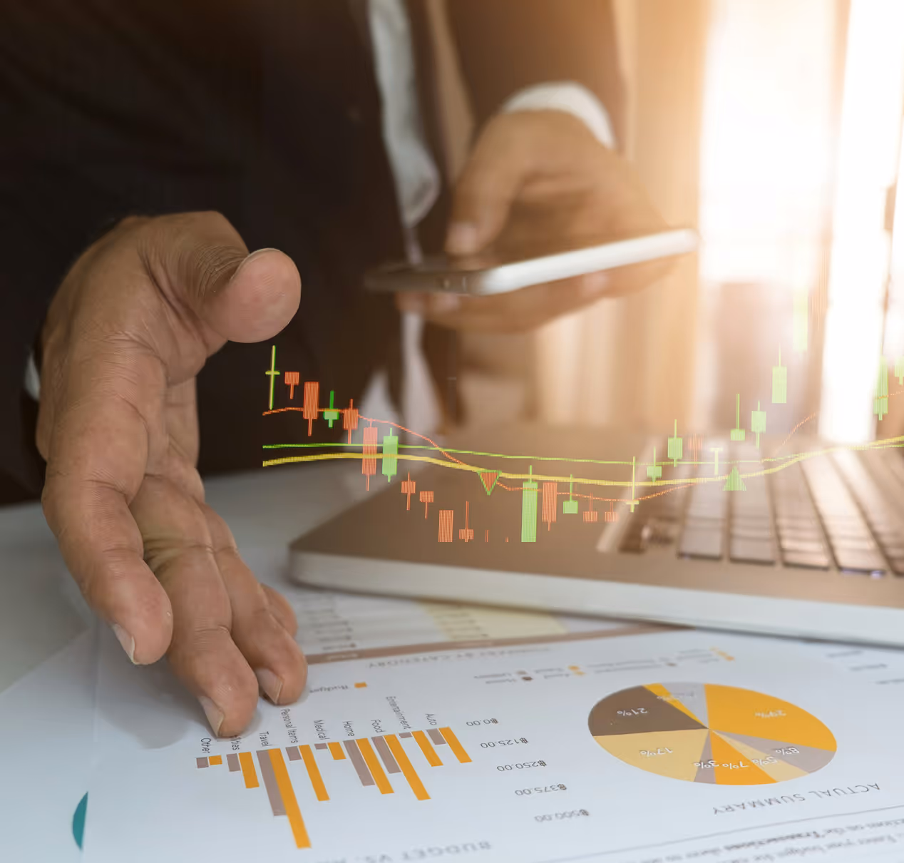Main courante de trading financier en surimpression sur une main tendue, un ordinateur portable et un smartphone, avec des graphiques et un diagramme circulaire sur une feuille.