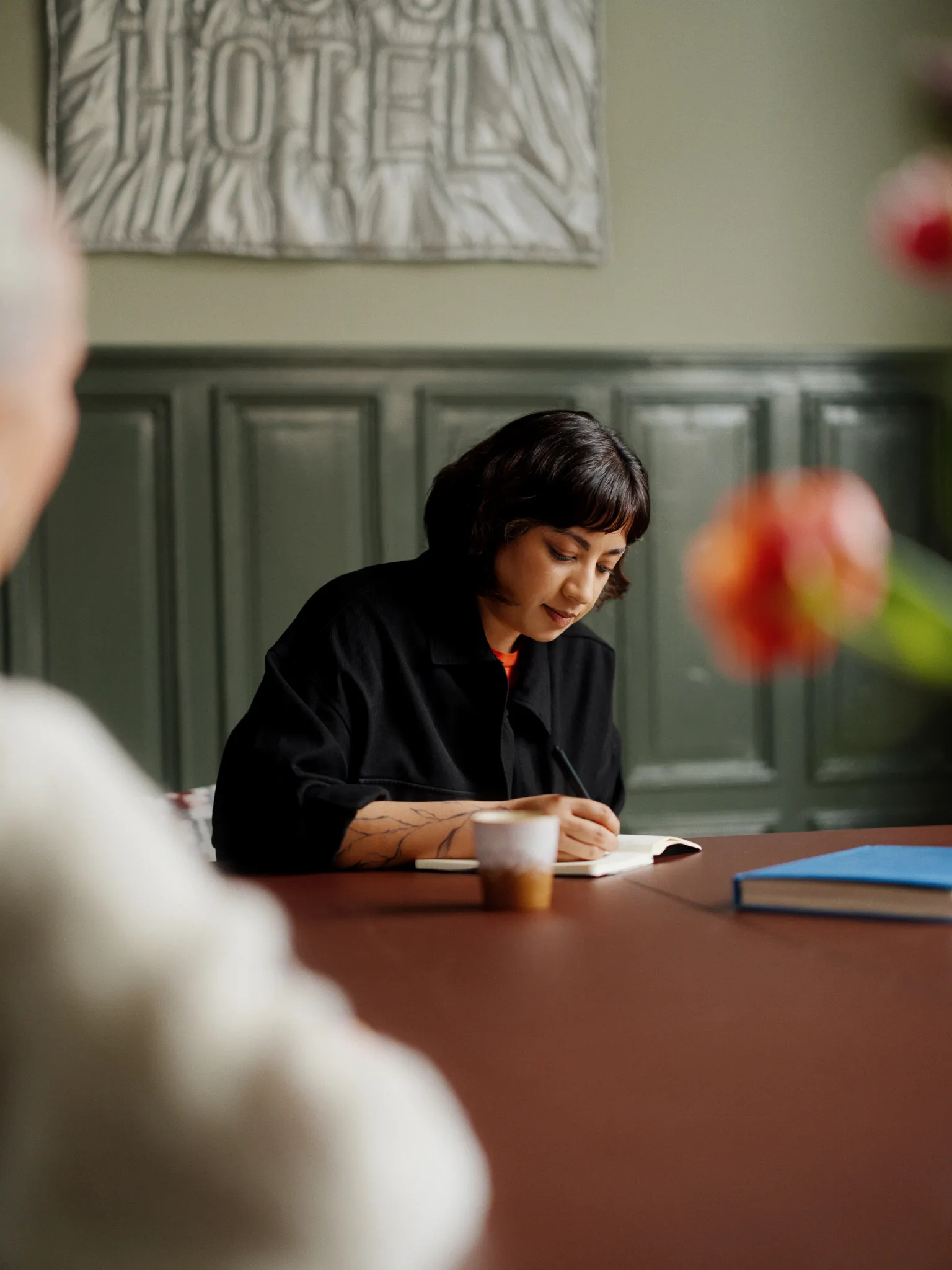 Consultant writing in a notebook during a strategic meeting at Dagger.