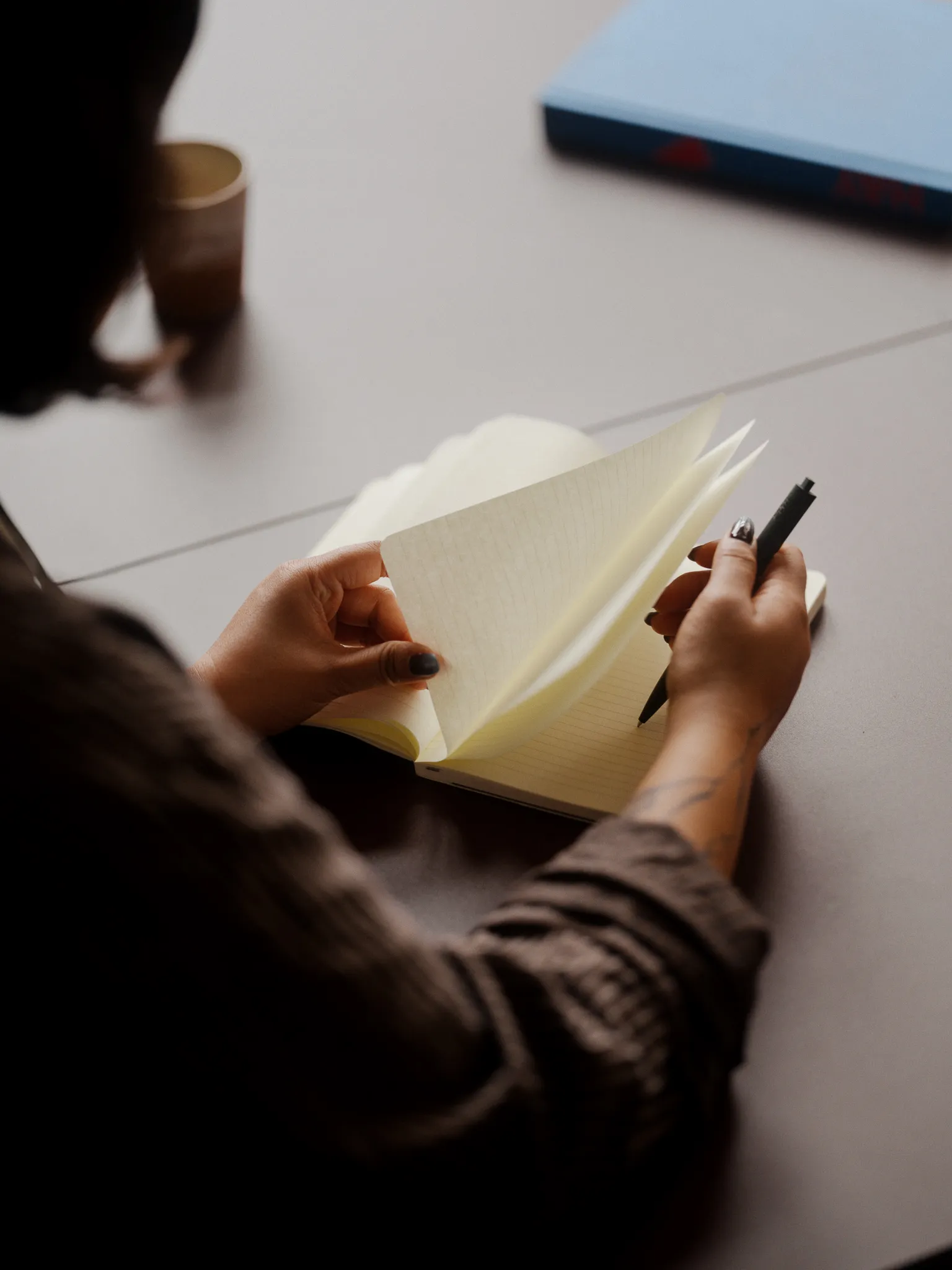 Close-up over-the-shoulder shot of a consultant writing in a notebook.
