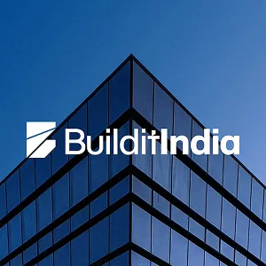 Modern glass building corner with blue sky background and BuilditIndia logo in white text.
