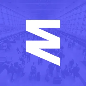 White stylized angular logo overlaying a blue-tinted image of people in an airport terminal.