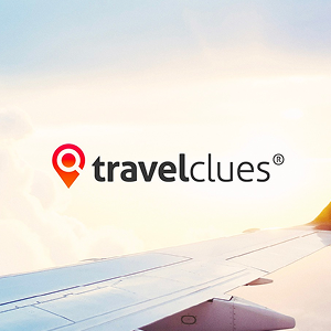 TravelClues logo with a red location pin icon over a photo of an airplane wing in the sky at sunrise or sunset.