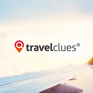 TravelClues logo with a red location pin icon over a photo of an airplane wing in the sky at sunrise or sunset.