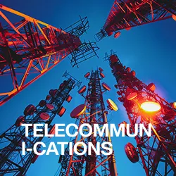 View looking up at multiple red telecommunications towers with antennas and dishes against a clear blue sky.