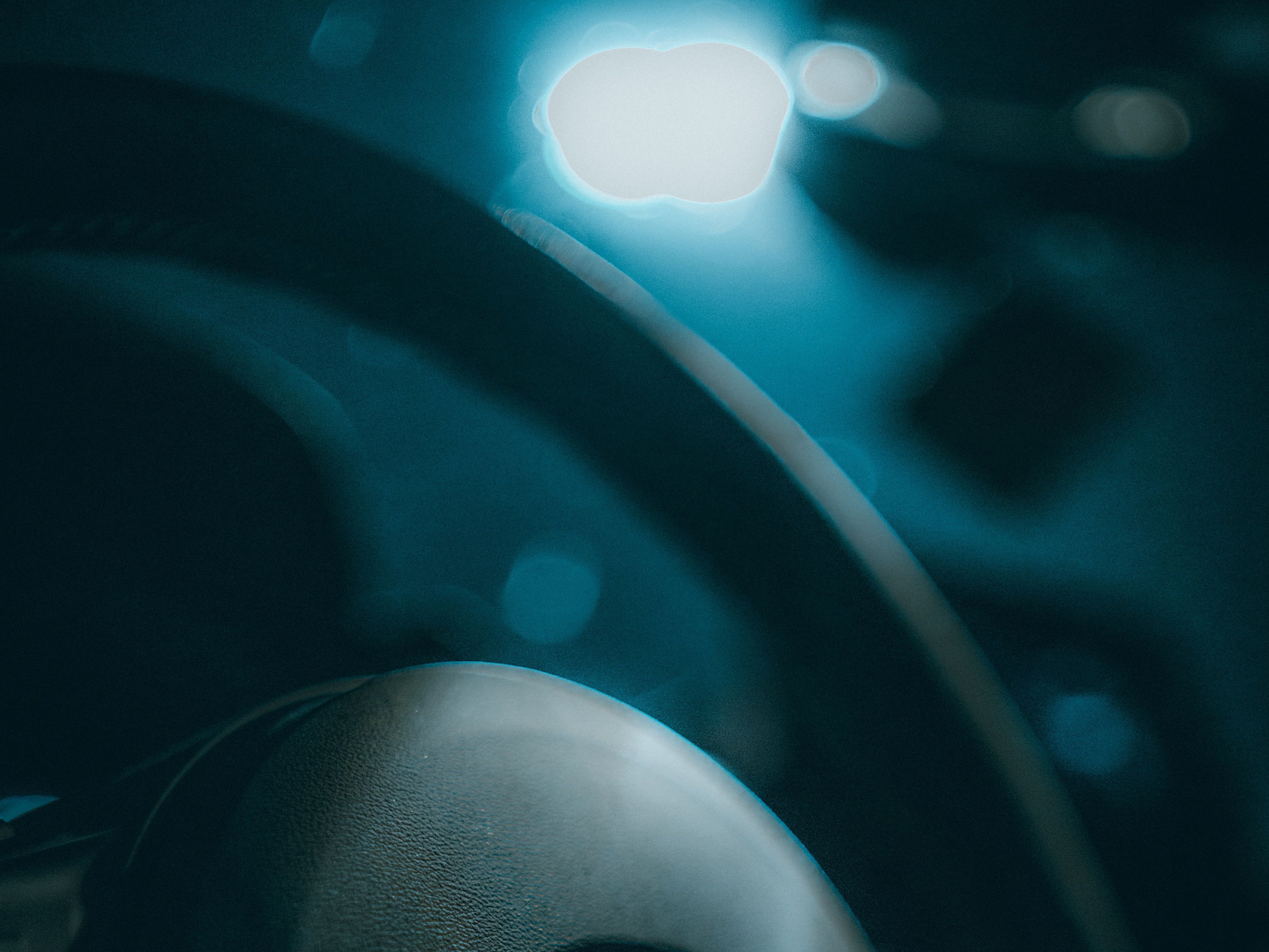 Smiling man in a gray suit driving a car, holding the steering wheel with one hand and the gear shift with the other.