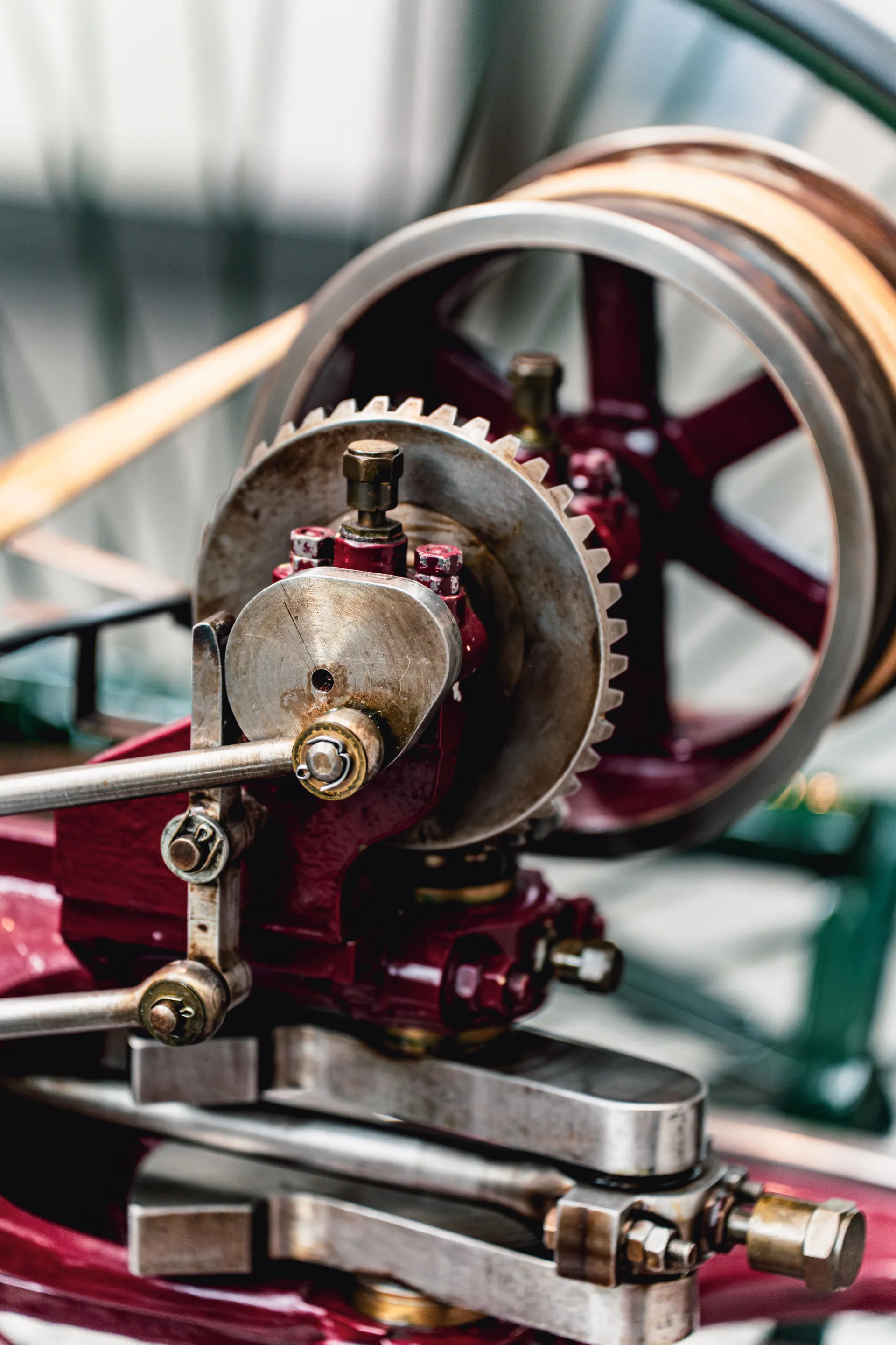 Close-up of vintage industrial machinery with gears, levers, and a large metal wheel.
