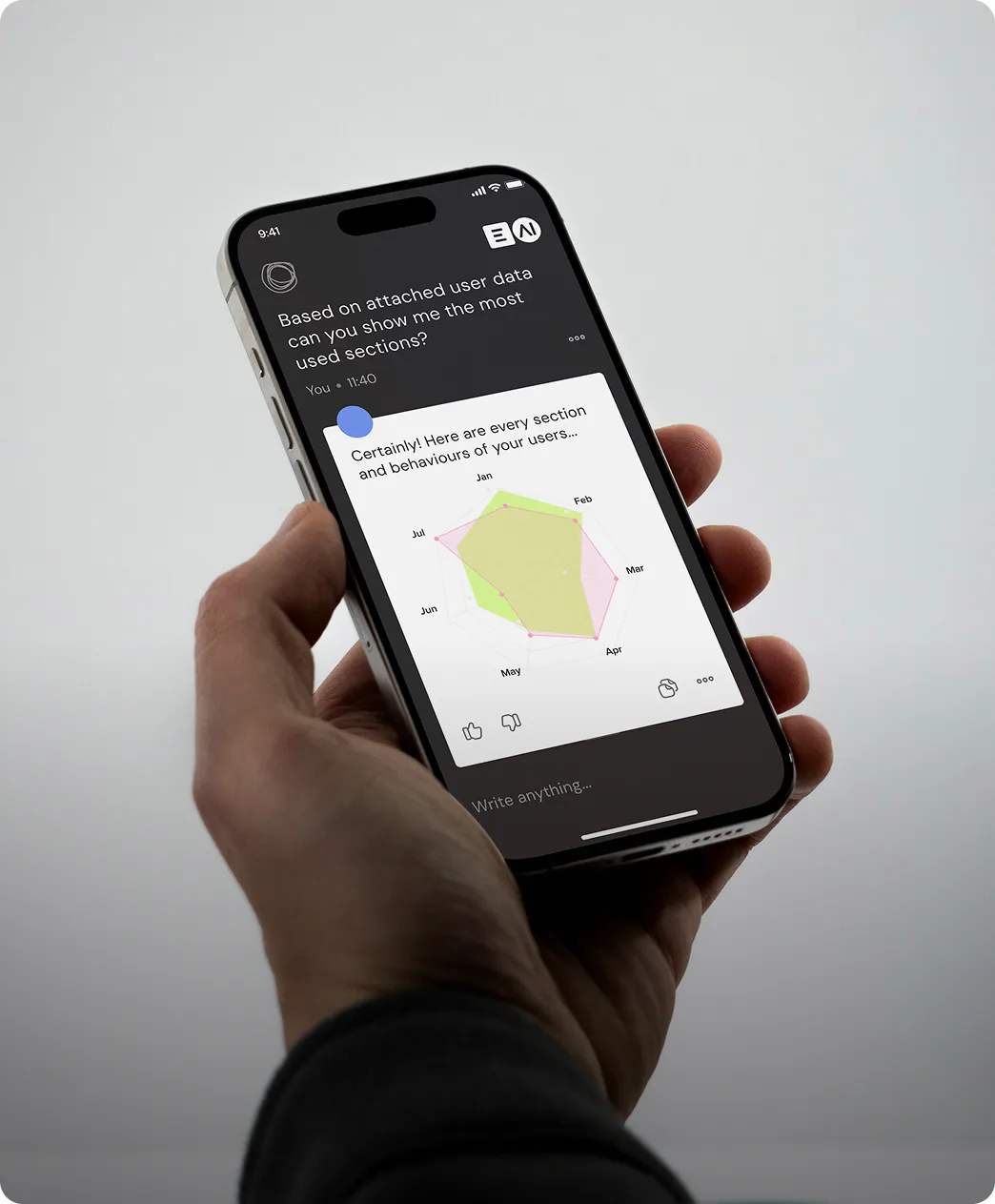 Hand holding a smartphone showing a chatbot conversation with a radar chart of user behavior by month.