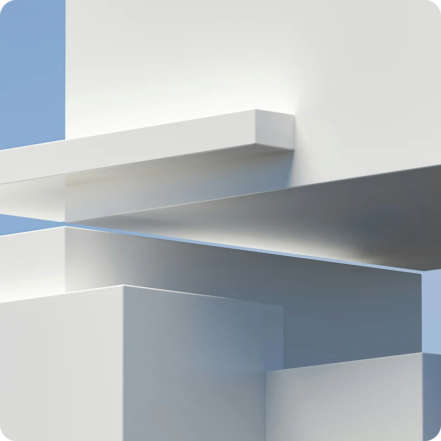 Abstract architectural composition of overlapping white and gray geometric blocks against a blue sky.