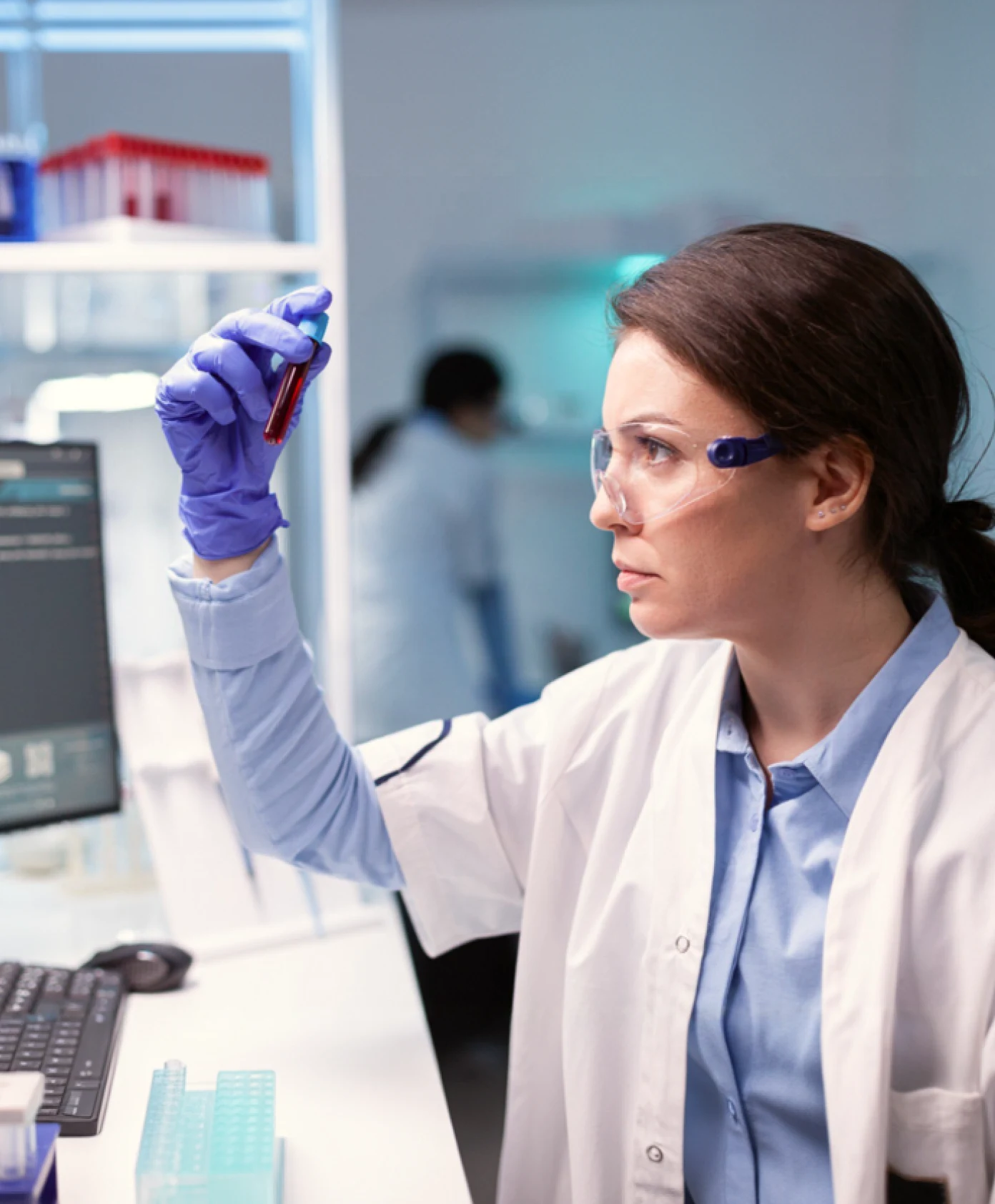 Two people sitting at a table with a laptop.