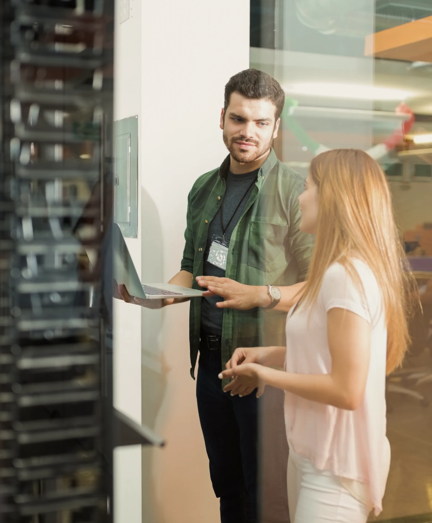 Two people sitting at a table with a laptop.
