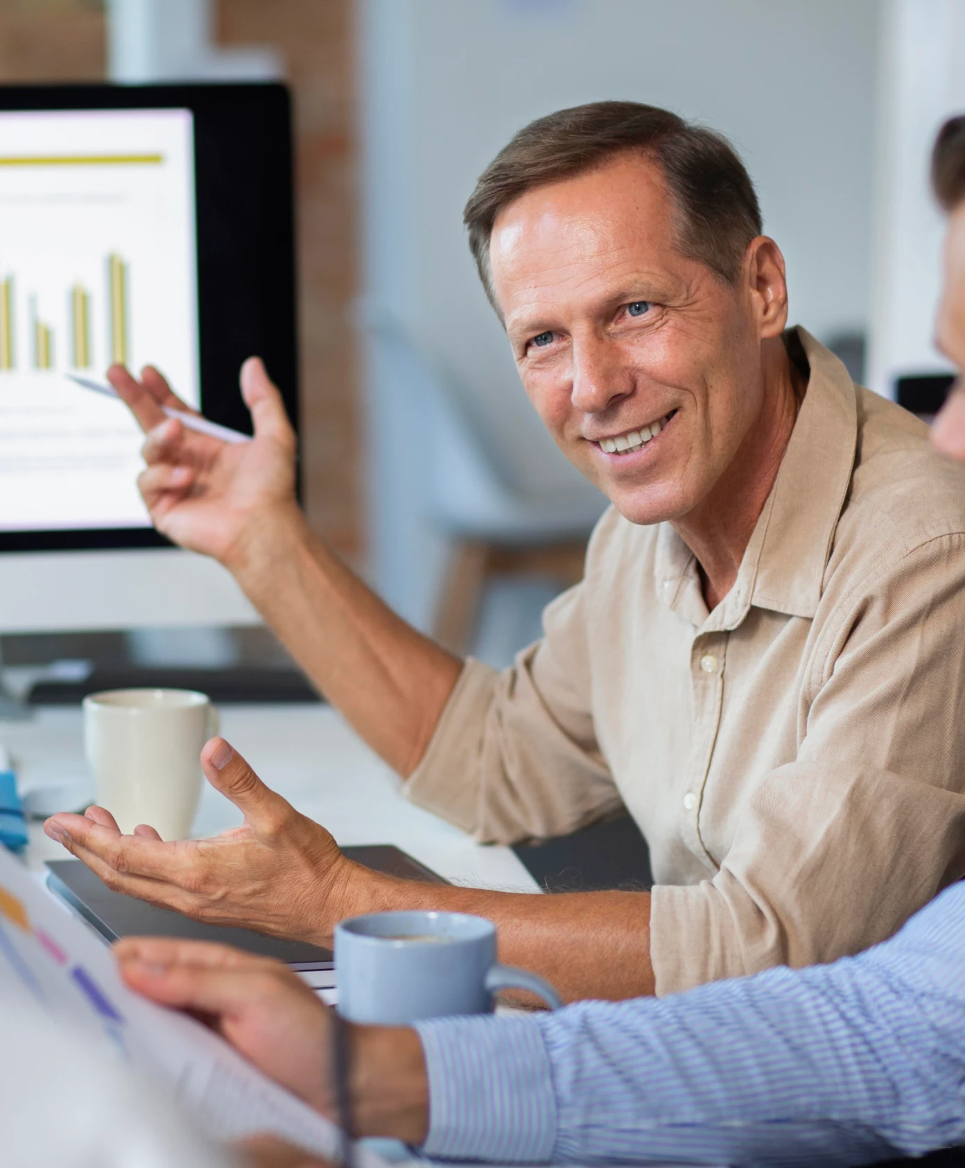 Two people sitting at a table with a laptop.