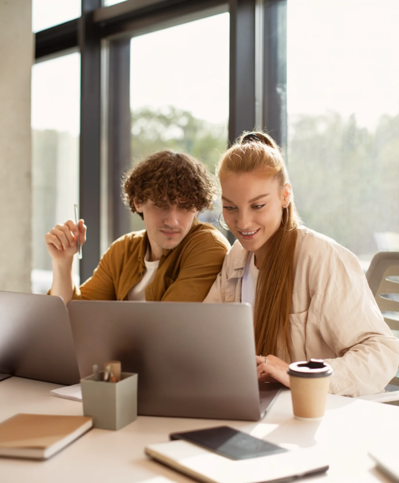 Two people sitting at a table with a laptop.