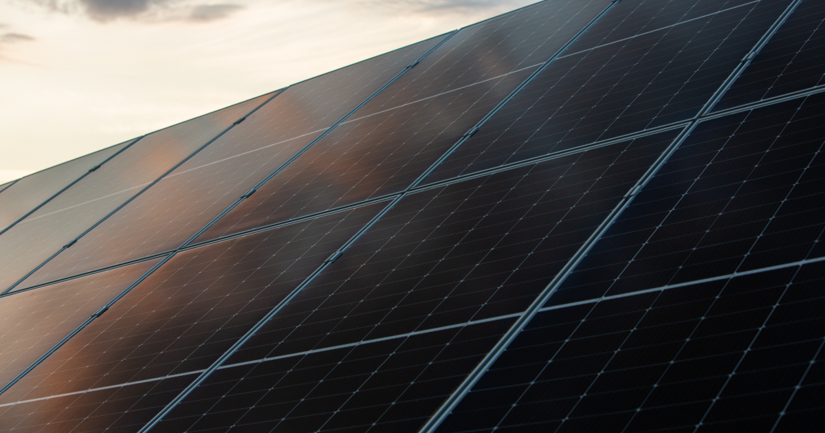 Two people sitting at a table with a laptop.