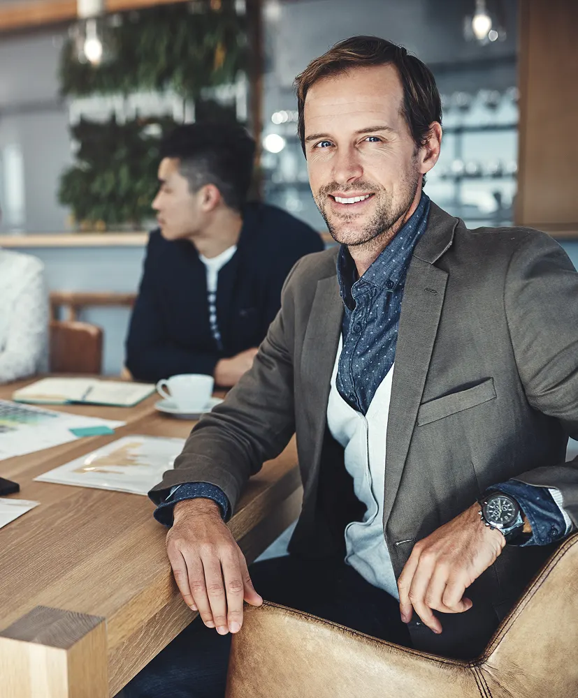 Two people sitting at a table with a laptop.