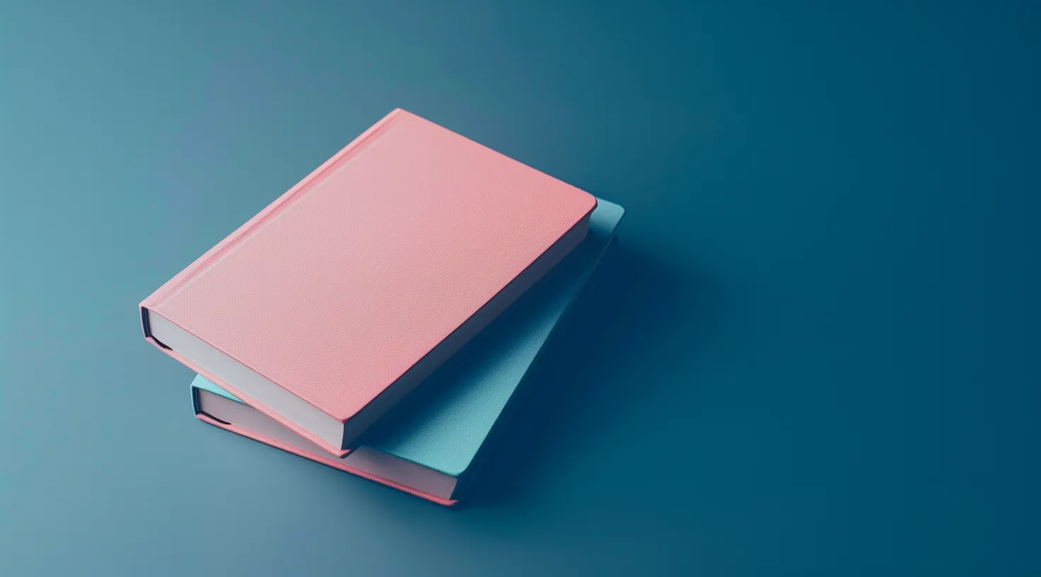 Two hardcover books stacked on a blue surface, one pink and one light blue.