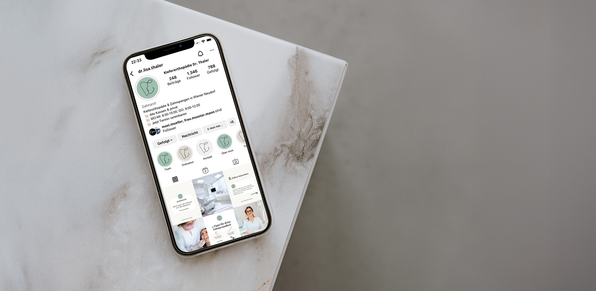 Smartphone auf Marmortisch, auf dem das Instagram-Profil des Kieferorthopäden Dr. Thaler mit Beiträgen und Symbolen angezeigt wird.