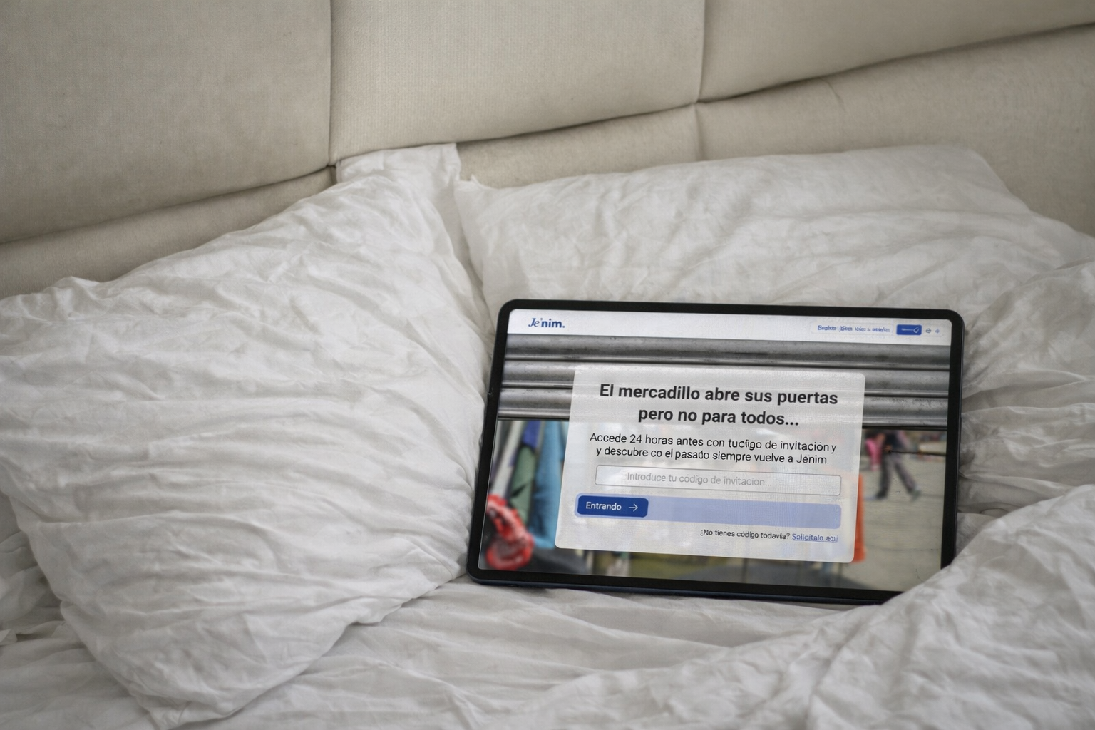 Tablet en una cama mostrando la página de pre-apertura del mercadillo de Je'nim con acceso anticipado