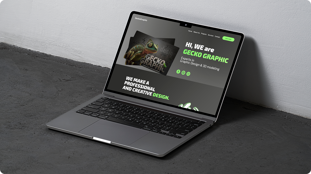 Open laptop on dark floor showing a website homepage with green and white text and a gecko image.