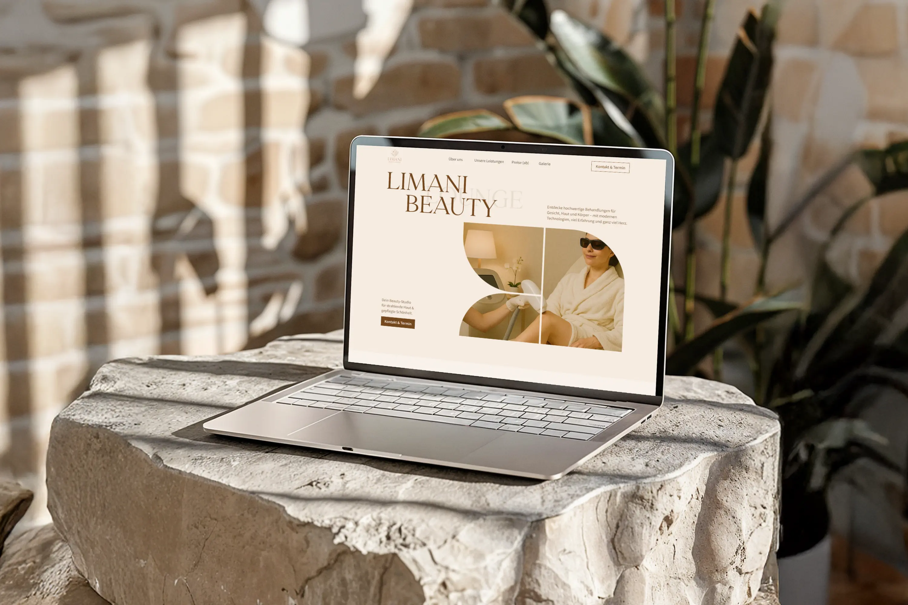 Open laptop on a stone surface displaying Limani Beauty website with an image of a woman in sunglasses and a bathrobe receiving a beauty treatment.