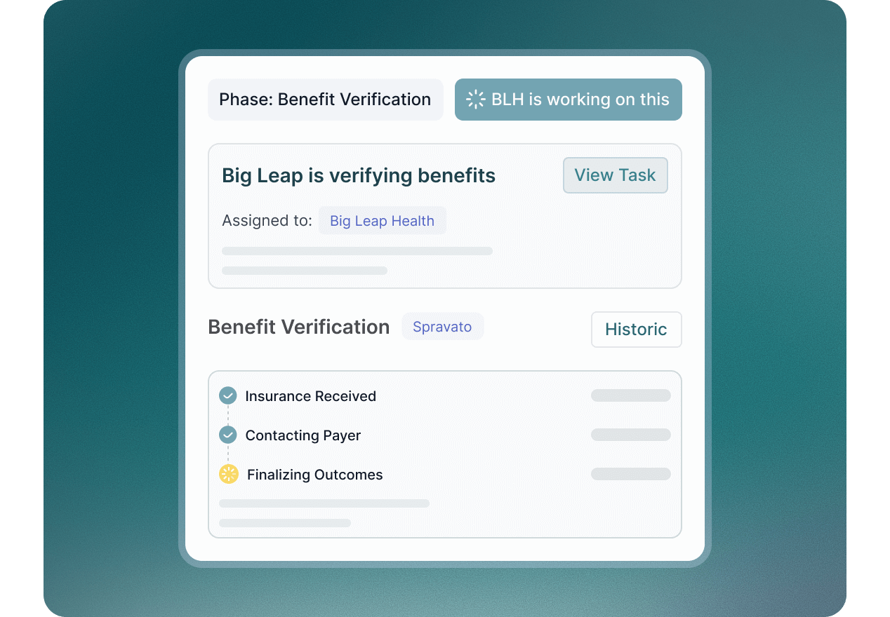 Smiling male doctor in blue scrubs with stethoscope typing on a laptop at a desk with medical documents.