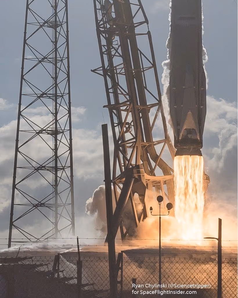 SpaceX Falcon 9 rocket launching with bright engine flames and smoke near the launch pad structure.