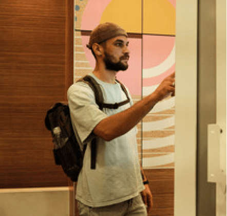 Stock image of a man in a backpack at an ordering kiosk