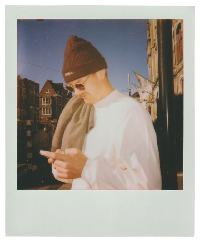 Polaroid: Julian Brandt in a beanie looking at his phone