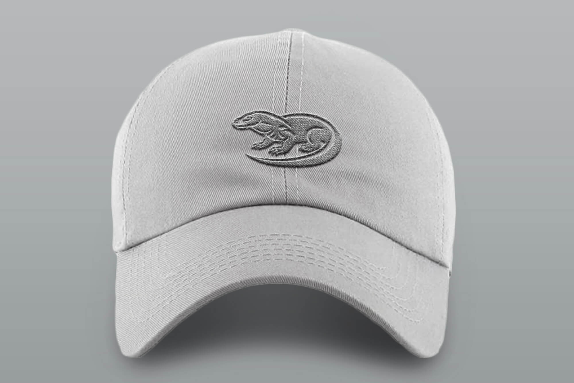 Hellgraue Baseballkappe mit einem gestickten Waran-Logo vorne.