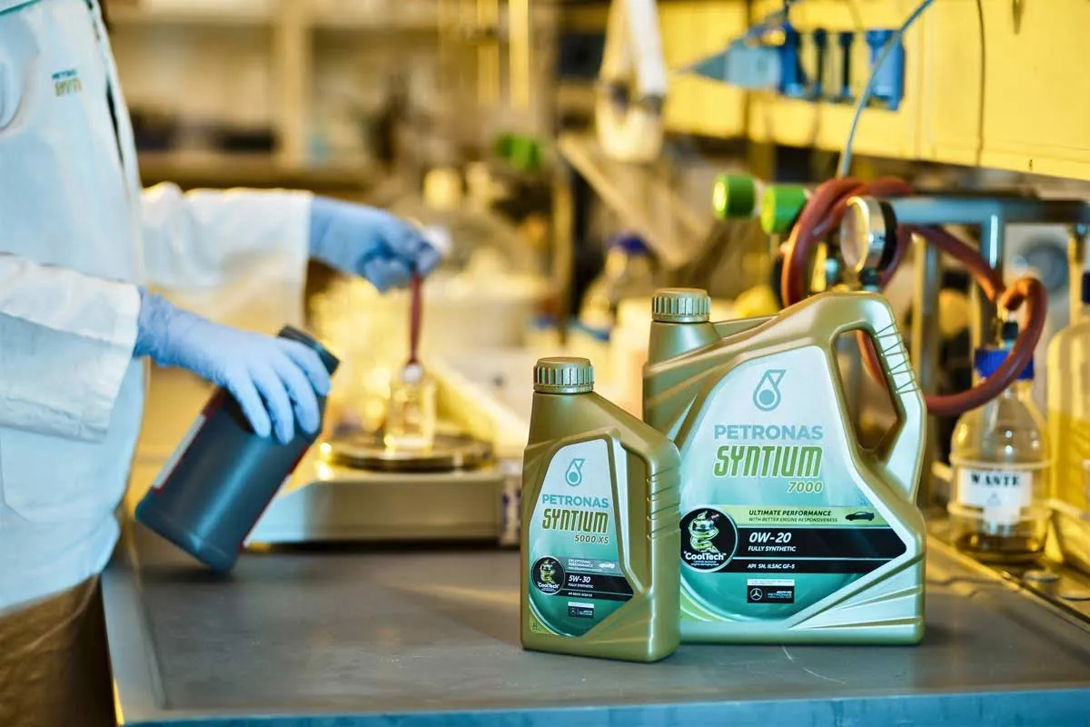 Twee flessen Petronas Syntium motorolie (5000 XS 5W-30 en 7000 0W-20) op een werkbank in een laboratorium