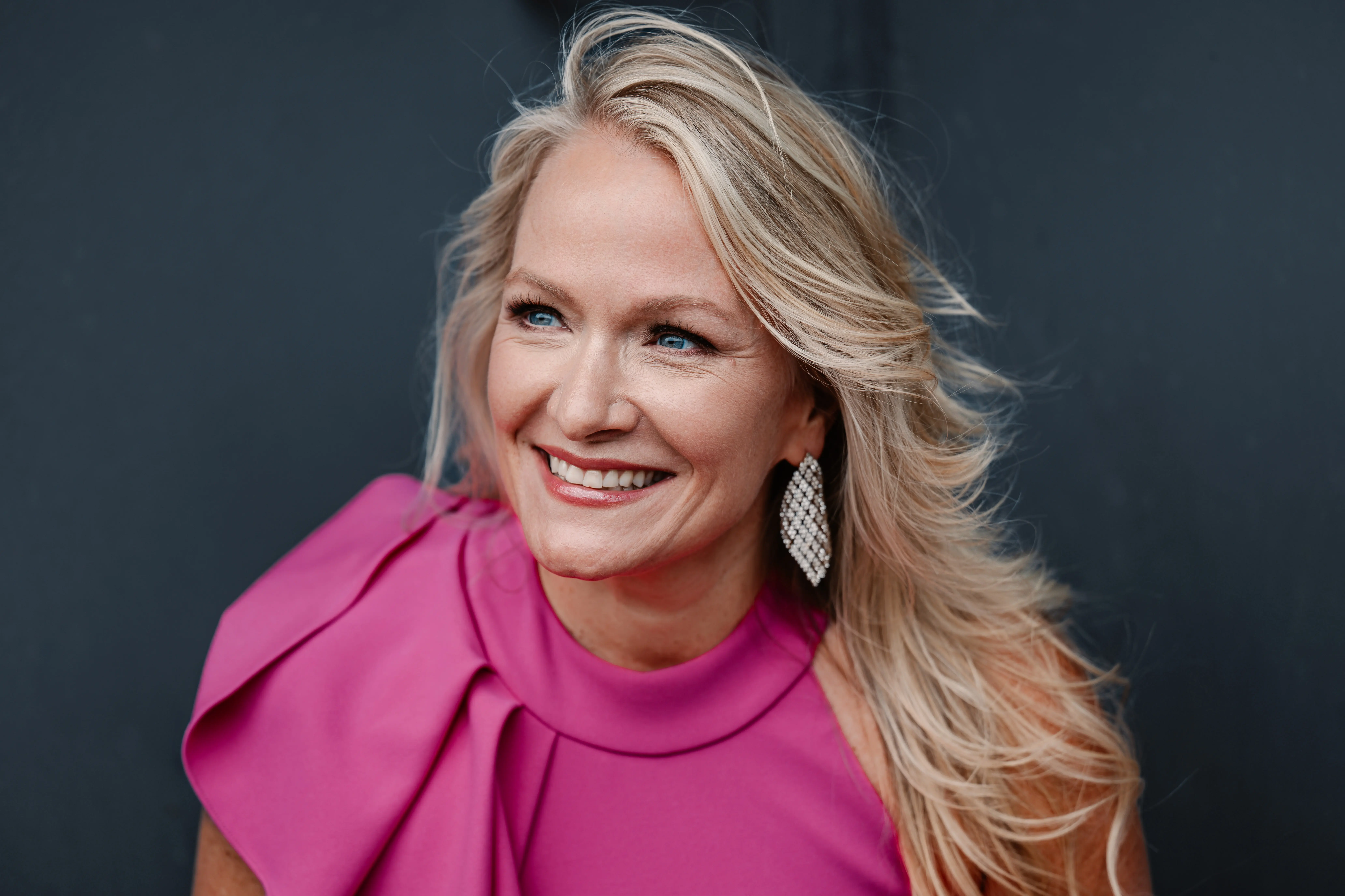 Man intensely playing a marimba with four mallets in an ornate room with decorative wallpaper and architectural details.