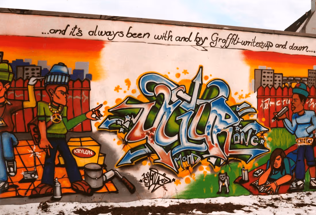 Buntes Graffiti-Mural mit stilisierten Schriftzügen und Figuren – Hip-Hop-Kultur