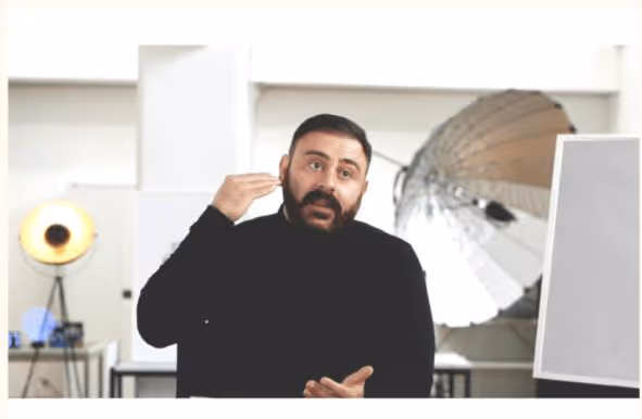 Mann spricht in einem Studio-Setting und erklärt etwas mit Gesten