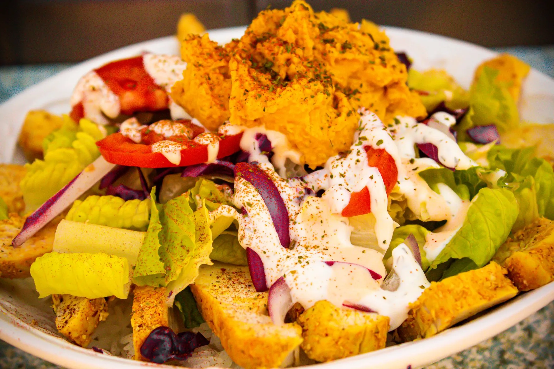 A plate of food with a salad and a sauce.