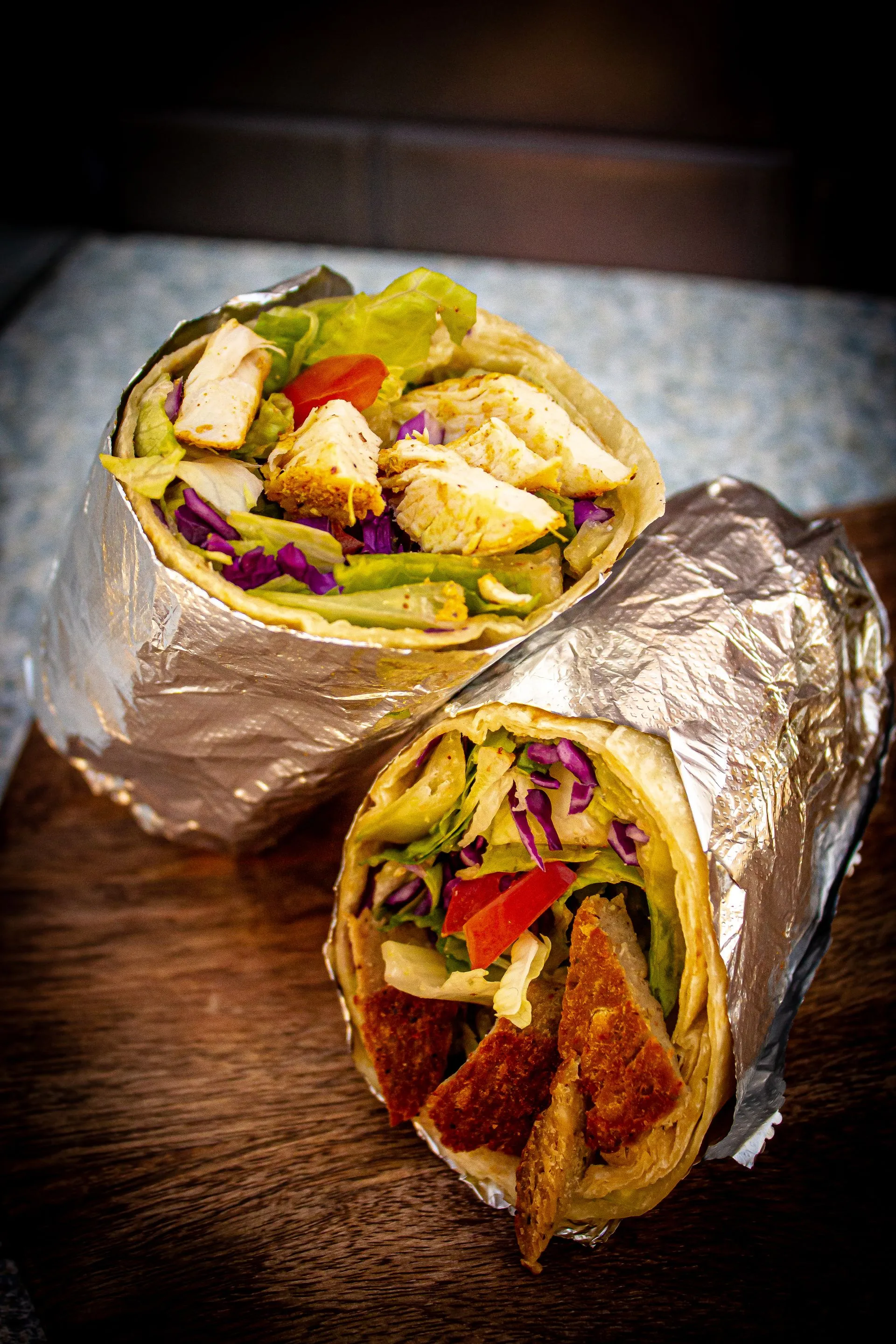 A wrap with meat and vegetables on a table.