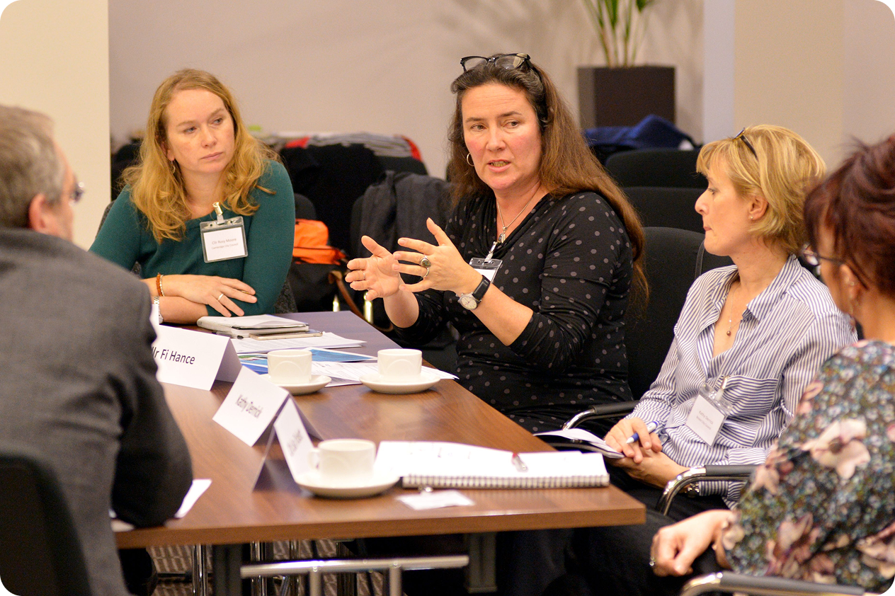 Professional women in a meeting, discussing and gesturing at conference table
