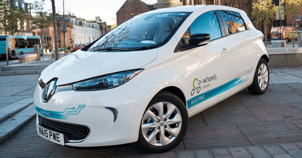 White Renault Zoe electric car parked on city street with car-sharing logo