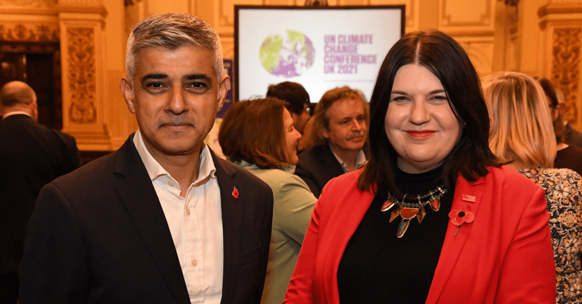 Two people at climate conference with poppy pins in ornate hall