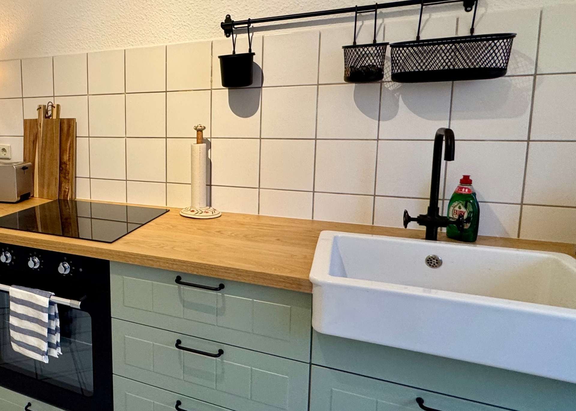 Grüne Desing Küche mit Retro Waschbecken, Holzbrett und Industrial Amarturen – gemütlich und modern eingerichtet
