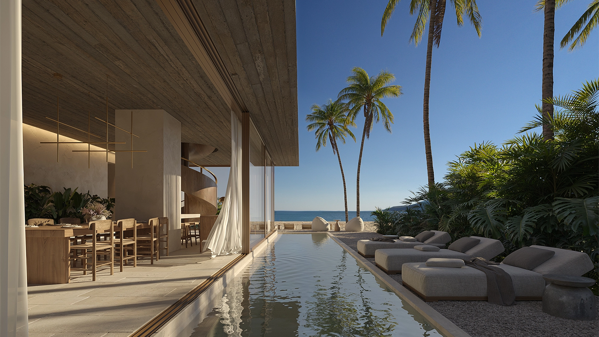 Modern beachfront home with an open dining area, narrow pool, palm trees, and four lounge chairs beside the pool facing the ocean.